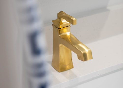 A bathroom interior with a white sink and a gold sink.