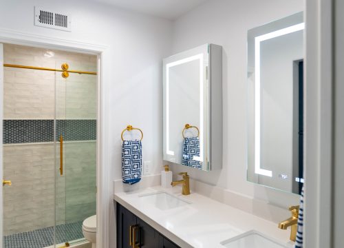 A bathroom setup featuring a white sink next to a gold sink, illustrating a refined and stylish atmosphere.