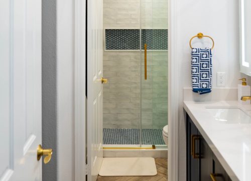 A stylish bathroom displaying a white sink and a gold sink, highlighting a contemporary aesthetic.