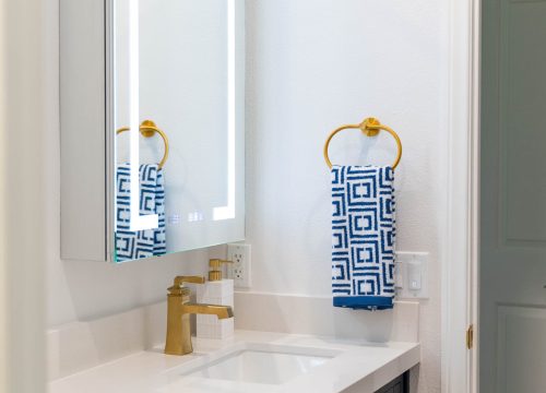 A bathroom setup featuring a white sink next to a gold sink.