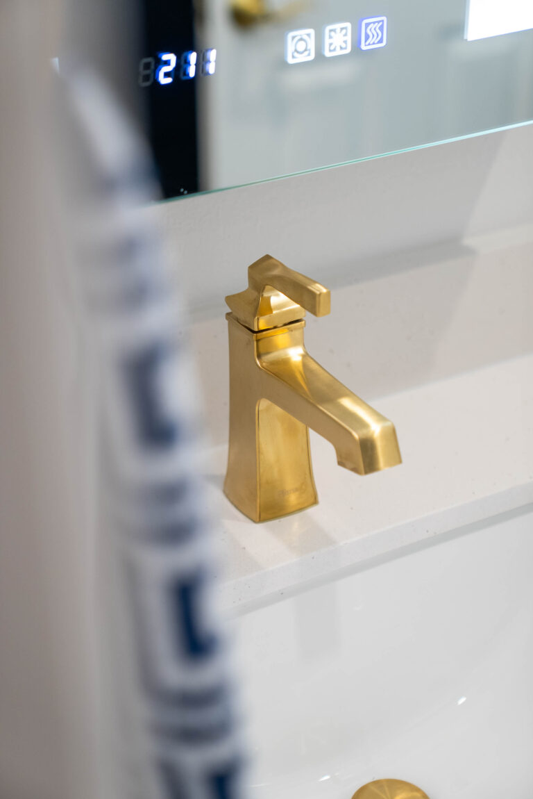 A bathroom interior with a white sink and a gold sink.