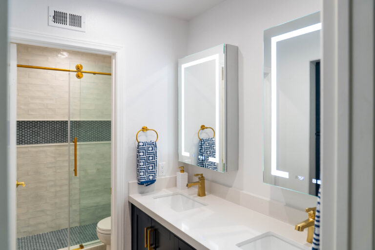A bathroom setup featuring a white sink next to a gold sink, illustrating a refined and stylish atmosphere.