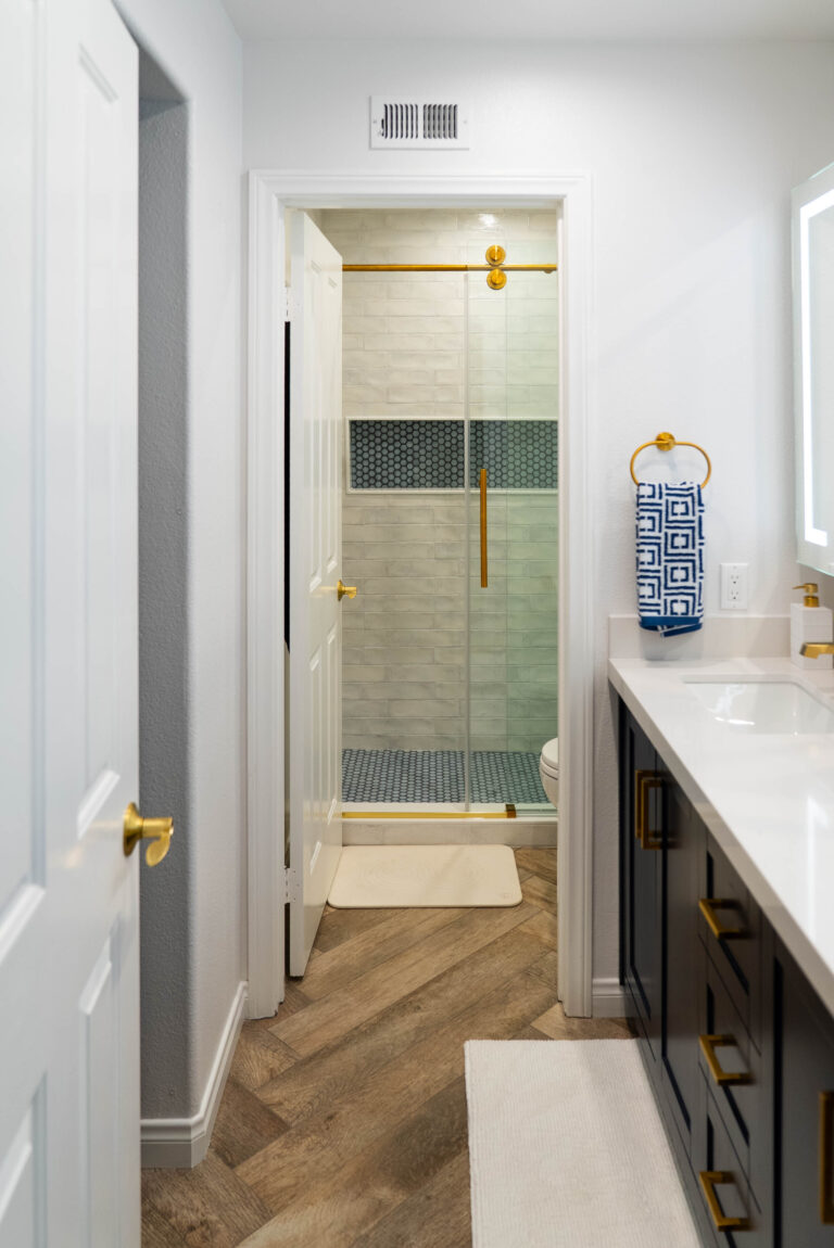 A stylish bathroom displaying a white sink and a gold sink, highlighting a contemporary aesthetic.