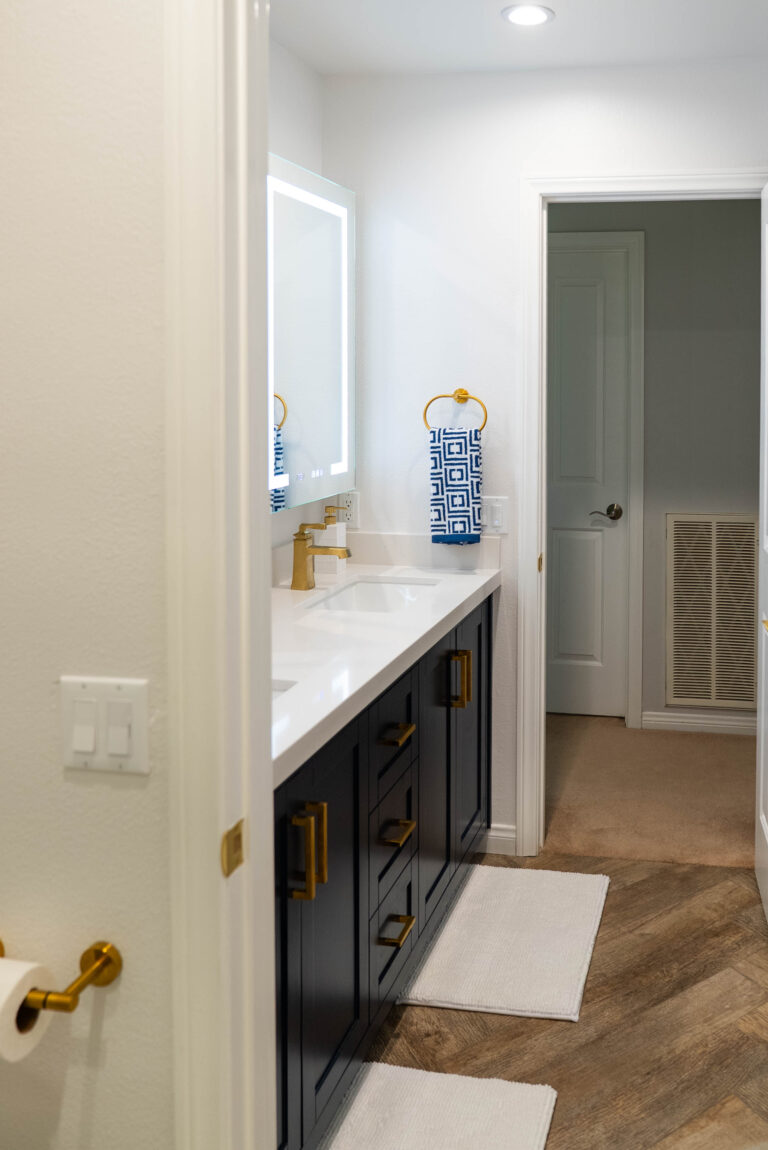 A bathroom featuring a white sink alongside a gold sink, showcasing a modern and elegant design.