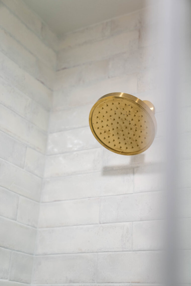 A modern bathroom featuring a gold shower .