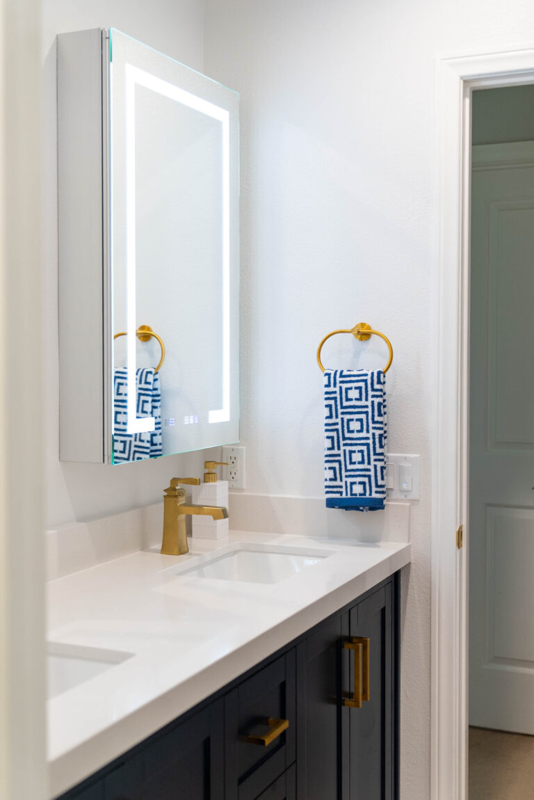 A bathroom setup featuring a white sink next to a gold sink.