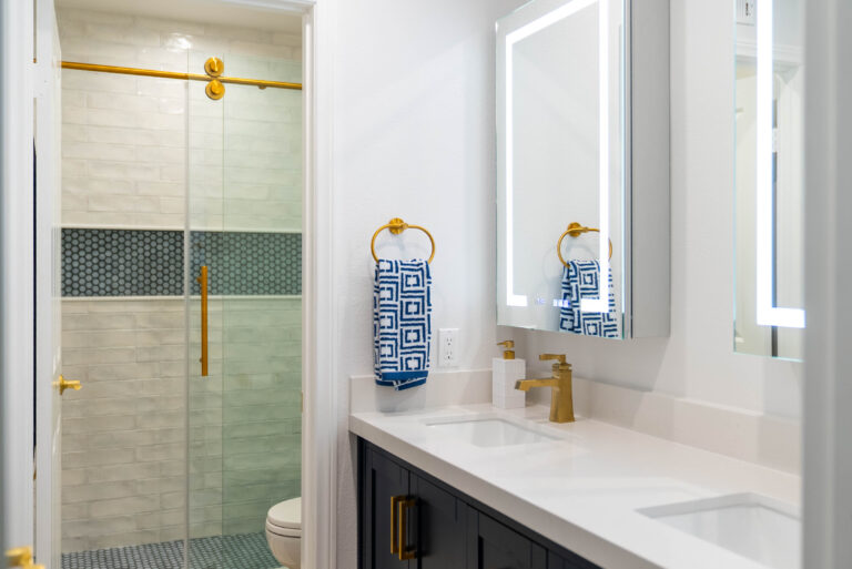 A bathroom scene displaying two mirrors and a sleek shower, highlighting a minimalist and functional design.